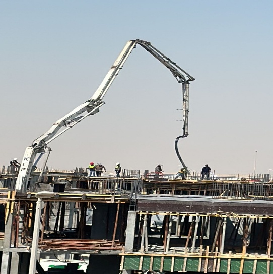 Concrete pump and construction team working on a building structure